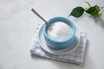Bowl and scoop with white sugar on wooden background. Food catalog