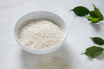 White rice (Thai Jasmine rice) in white bowl on wooden texture background, Natural food high in protein