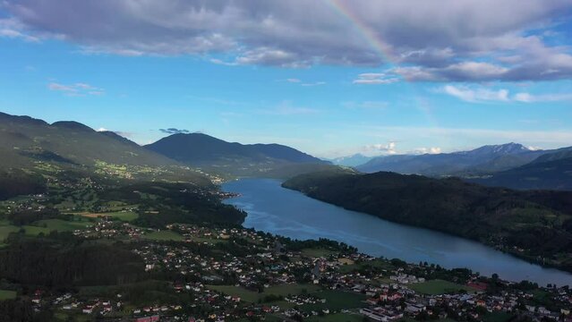 Rainbow over Millstatter sea in Austria, in the Dolomites. Drone video of the lake and houses near it, the calm atmosphere of the Austrian hinterland