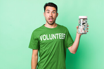 young adult hispanic man looking very shocked or surprised. donation concept