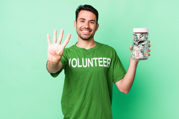 young adult hispanic man smiling and looking friendly, showing number four. donation concept