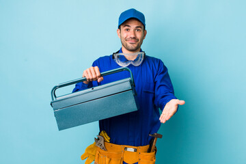 young adult hispanic man smiling happily with friendly and  offering and showing a concept. toolbox...