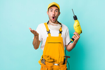 young adult hispanic man amazed, shocked and astonished with an unbelievable surprise. worker and...