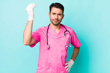 young adult hispanic man making capice or money gesture, telling you to pay. veterinarian concept