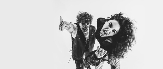 Black and white portrait of rock music fans, young boy and girl wearing black leather outfits...