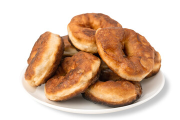 Pile of fresh homemade round donuts in a plate isolated on white background. Brown fried doughnuts. Yeast dough products, sweet pastries isolate.