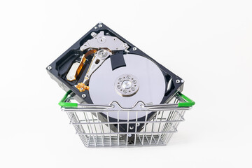 Hard drive in the shopping cart on a white background, HDD disk, memory device. The concept of repairing, buying, selling a harddrive for a computer or laptop. Storage and recovery of digital data.