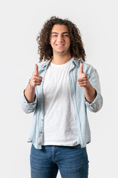 Close up of young good looking man with long and curly hair is pointing with his finger, isolated on white background