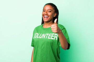 young adult black woman feeling proud,smiling positively with thumbs up