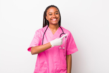 young adult black woman smiling cheerfully, feeling happy and pointing to the side. veterinarian...