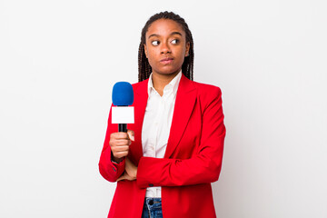 young adult black woman shrugging, feeling confused and uncertain. presenter and microphone concept