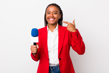 young adult black woman smiling confidently pointing to own broad smile. presenter and microphone...