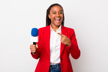 young adult black woman looking excited and surprised pointing to the side. presenter and...