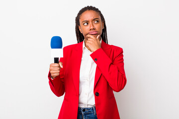 young adult black woman thinking, feeling doubtful and confused. presenter and microphone concept