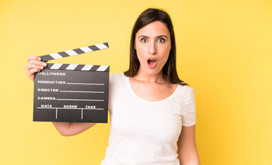 young adult pretty woman looking very shocked or surprised. cinema clapper concept