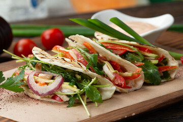 Tacos with vegetables on the board.