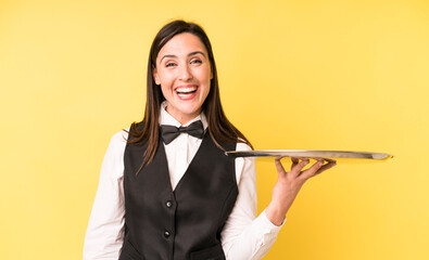 young adult pretty woman looking happy and pleasantly surprised. waiter and tray concept