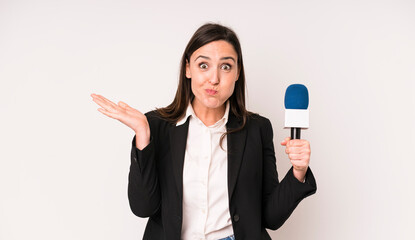 young adult pretty woman feeling puzzled and confused and doubting. presenter with a microphone...