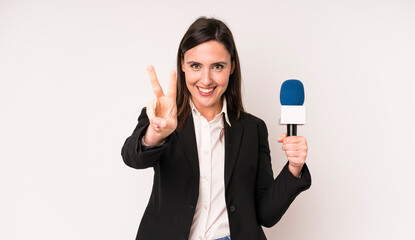young adult pretty woman smiling and looking happy, gesturing victory or peace. presenter with a...