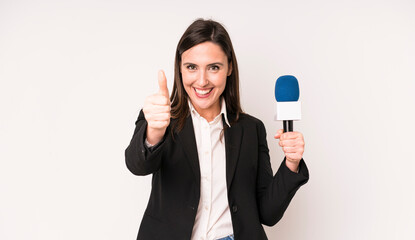 young adult pretty woman feeling proud,smiling positively with thumbs up. presenter with a...