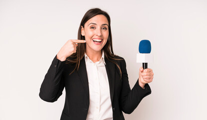 young adult pretty woman smiling confidently pointing to own broad smile. presenter with a...