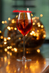 Wine glass with red cocktail. against the backdrop of lights.