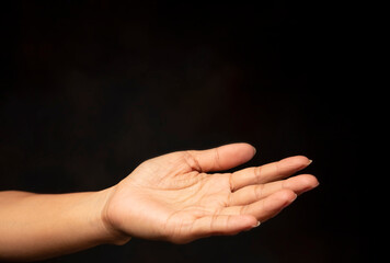 Praying hand with faith in religion and belief in god on black background. Power of hope and...