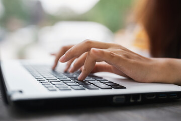 Close up, woman hands typing on computer keyboard . Female working on laptop at office, internet marketing