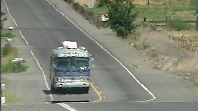OLDER CHARTER BUS DRIVING ALONG FREEWAY