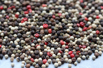 Black, green, pink and white peppercorns close up photo. Seasoning texture. 