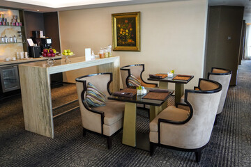 The interior of the hotel and restaurant building is very beautiful and modern. Chairs and tables are neatly arranged with glass windows facing out.