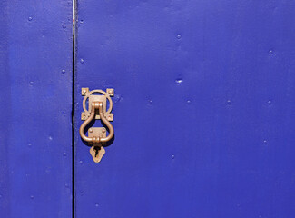 Vintage exterior lock and doorknob on dark blue door. European style door lock.