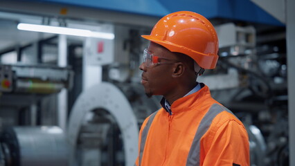 African american engineer looking camera in industrial manufacturing factory