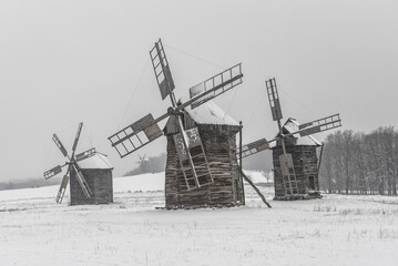 Old vintage wooden mill in winter, foggy landscape