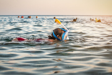 woman in full face snorkeling mask swims in the sea