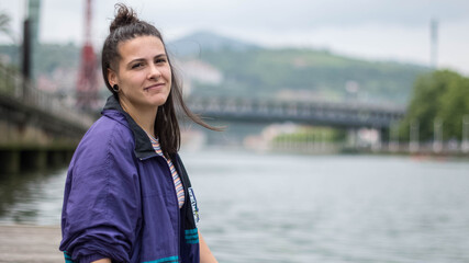 smiling girl sitting in front of the river