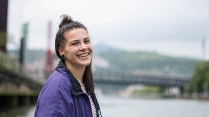 smiling girl sitting in front of the river