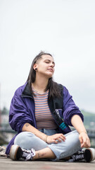 smiling girl sitting in front of the river