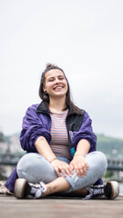 smiling girl sitting in front of the river