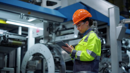 Engineer looking tablet computer in energy company. Modern factory concept.