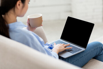 Over shoulder shot of asian woman using laptop, mockup © Prostock-studio