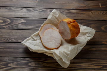 sausage in wrapping paper on a wooden table.