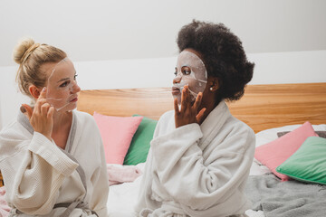 The young women in masks are sitting at the spa