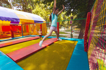 Fototapeta na wymiar The joyful children are jumping in the trampoline park