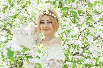Fototapeta premium Bride at spring garden. Beautiful mix race lady in romantic lace dress with make up and flower wreath