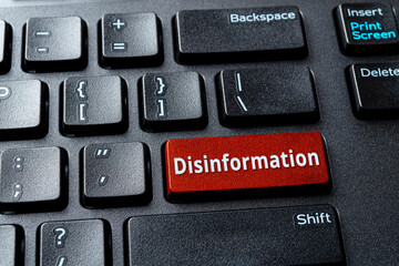Disinformation red key on the desktop keyboard. Warning message on the computer enter key....