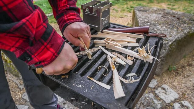 Zeitlupe Filmmaterial  St&uuml;ck Fichte Holz wird mit scharfen Jagd Messer Holzfedern geschnitzt um Feuer machen mit Feuerstahl und Hobo Kocher, Deutschland
