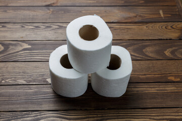 slide of toilet paper rolls on a wooden background.