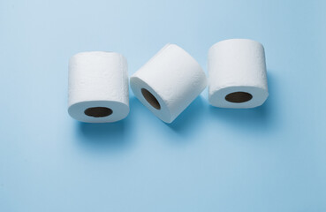 three rolls of toilet paper on a blue background.