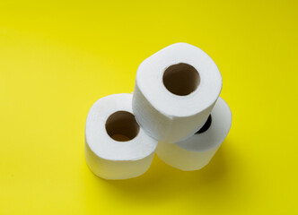 slide of toilet paper rolls on a yellow background.